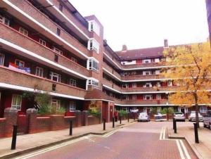 een lege straat voor een gebouw bij White City private room in Londen