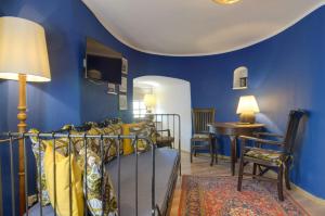 sypialnia z niebieskimi ścianami, łóżkiem i stołem w obiekcie Baszta Grodzka w Jeleniej Górze