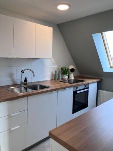 a kitchen with white cabinets and a sink at Ferienwohnung Weitblick in Bad Schussenried +8 photos