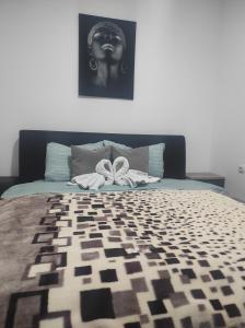 a bedroom with a bed with a black and white comforter at Cera luxe apartment in Soko Banja