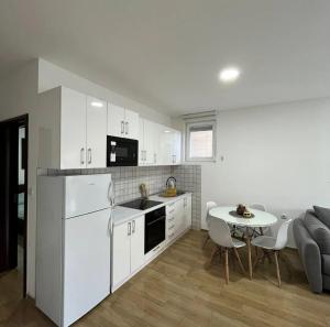 a kitchen with white appliances and a table and a couch at Cera luxe apartment in Soko Banja +15 photos