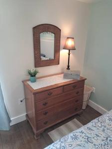 a bedroom with a dresser with a lamp and a mirror at The Cottage at Moore House in Florence