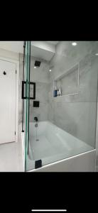 a bath tub in a bathroom with a glass door at 6 BEDROOM MODERN AND LUXURY HOME in Welland