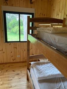Ce dortoir comprend 2 lits superposés et une fenêtre. dans l'établissement Chacra Celeste: montañas y mar, à Piriápolis