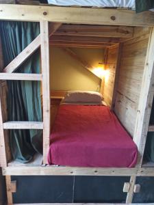 a bunk bed in a cabin with a red mattress at Jardin de Epicuro in Colonia Chapadmalal