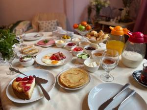 a table with plates of breakfast food on it at My Home Guest House in Baku
