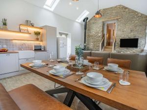 ein Esszimmer mit einem Holztisch und einer Küche in der Unterkunft 3 bed in Llandysul 87071 in Pencader