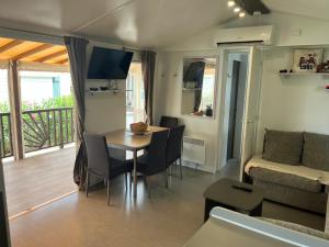 a living room with a table and a couch at Mobil home camping 4* la carabasse Vias in Vias
