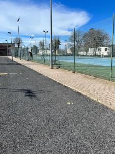 une rue vide avec une clôture et un terrain de football dans l'établissement Mobil home camping 4* la carabasse Vias, à Vias