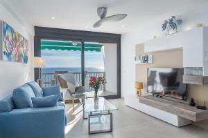 a living room with a blue couch and a fireplace at Appartement PM 25 in Fuengirola