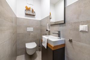 a bathroom with a white sink and a toilet at Top 21 Alpe Maritima - Feriendomizil am Ossiachersee mit Seeblick in Annenheim +16 photos
