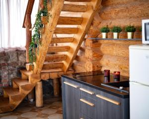 una cocina con escalera de madera en una cabaña en Metsapiiga Puhkemaja, 