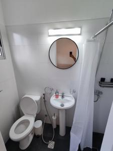 a bathroom with a toilet and a sink and a mirror at Hermoso Apartamento de 3 dormitorios en punta del este in Punta del Este +8 photos