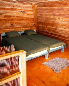 的住宿－Metsapiiga Puhkemaja，木墙客房的一张床位