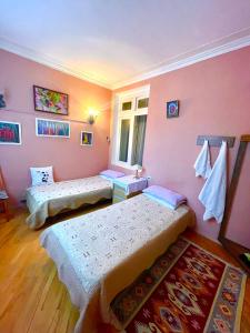 2 camas en una habitación con paredes rosas en My Home Guest House en Bakú