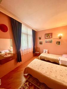 um quarto de hotel com duas camas e uma janela em My Home Guest House em Baku