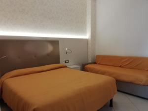 ソットマリーナにあるB&B Metropols Sottomarinaのベッドルーム1室(ベッド2台、ソファ付)