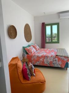 a bedroom with a bed and an orange ottoman at Secret Garden - Apartment with jacuzzi in Kampos Paros