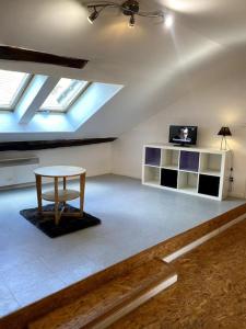 uma sala de estar com uma mesa e uma televisão num sótão em Studio Orgelet-Lac de Vouglans em Orgelet