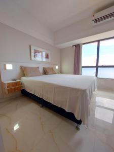 1 dormitorio con cama grande y ventana grande en Flat Tropical Executive, en Manaus