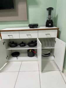 a kitchen with white cupboards with pots and pans at Kitnet na cidade nova in Ananindeua