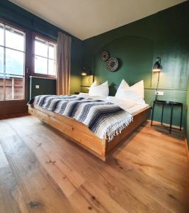 a bedroom with a wooden bed in a green wall at Gruberwirt Apartment mit Blick auf die Berge GW 4 in Innsbruck