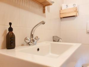 a white sink with a soap dispenser next to it at Gruberwirt Apartment mit Blick auf die Berge GW 4 in Innsbruck