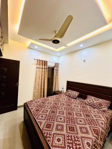 een slaapkamer met een bed met een plafond bij Capital Lodges in Gujrānwāla