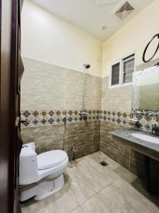 a bathroom with a toilet and a sink at Capital Lodges in Gujrānwāla