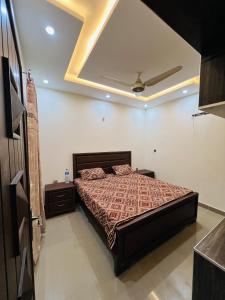 a bedroom with a bed and a ceiling at Capital Lodges in Gujrānwāla