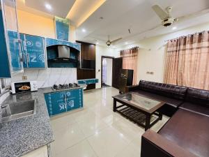 una cucina e un soggiorno con un divano e un tavolo di Capital Lodges a Gujrānwāla
