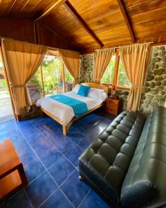1 dormitorio con cama y sofá en Hostería Arasari, en Mindo