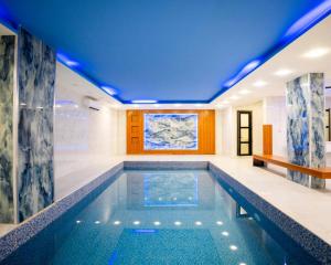 a pool in a house with a blue ceiling at Ward Hotel Basra in Al Başrah