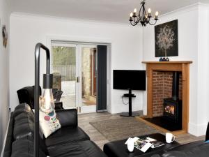 a living room with a black couch and a fireplace at 3 bed in Hamsterley 81503 in Evenwood