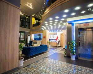 a lobby with a blue couch in a building at Ward Hotel Basra in Al Başrah