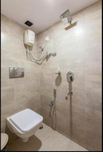 a bathroom with a shower with a toilet and a sink at ABZA DELUXE DORMITORY in Mumbai