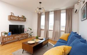 a living room with a blue couch and a tv at Athenee Calea Victoriei Apartment in Bucharest