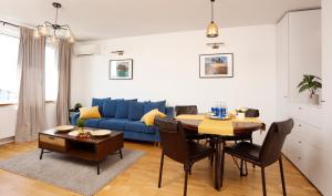 a living room with a blue couch and a table at Athenee Calea Victoriei Apartment in Bucharest