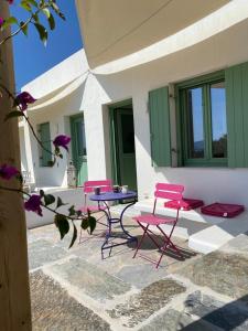 a group of pink chairs and a table on a patio at Secret Garden - Apartment with jacuzzi in Kampos Paros