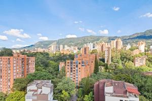 uma vista para uma cidade com edifícios altos e árvores em Stylish Estudio La Frontera em Medellín