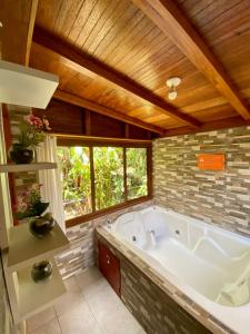 a large bathroom with a large tub andwindows at Hostería Arasari in Mindo