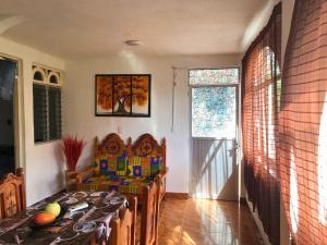 a dining room with a table and a chair in a room at Suite Victoria Acapulco in Acapulco