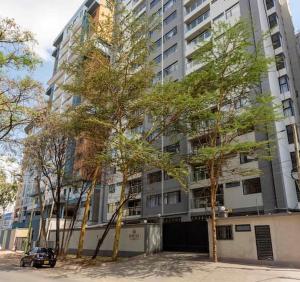 a tall building with trees in front of it at The olive in Nairobi