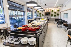 a buffet line with food on it in a restaurant at Mirante Hotel in Governador Valadares +22 photos