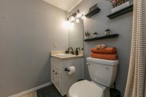 a bathroom with a toilet and a sink and a mirror at ★Modern,CozyCouple's Getaway w/Relaxing Patio! in Austin