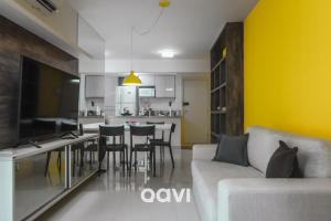 sala de estar con sofá blanco y pared amarilla en Qavi - Flat Resort Beira Mar Cotovelo #InMare133, en Parnamirim