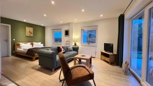 a living room with a couch and a bed and a television at Kleemann´s Apartment**** in Zossen