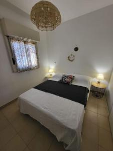 ein Schlafzimmer mit einem Bett, einem Fenster und zwei Lampen in der Unterkunft Charmant T2 climatisé proche Calvi centre in Calvi