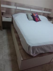 a bed in a room with a wooden bed frame at Lupita 3 in General Roca