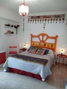 マラガにあるLa Casa de La Abuela Rosyのベッドルーム1室(ベッド1台、テーブル2台、シャンデリア付)
